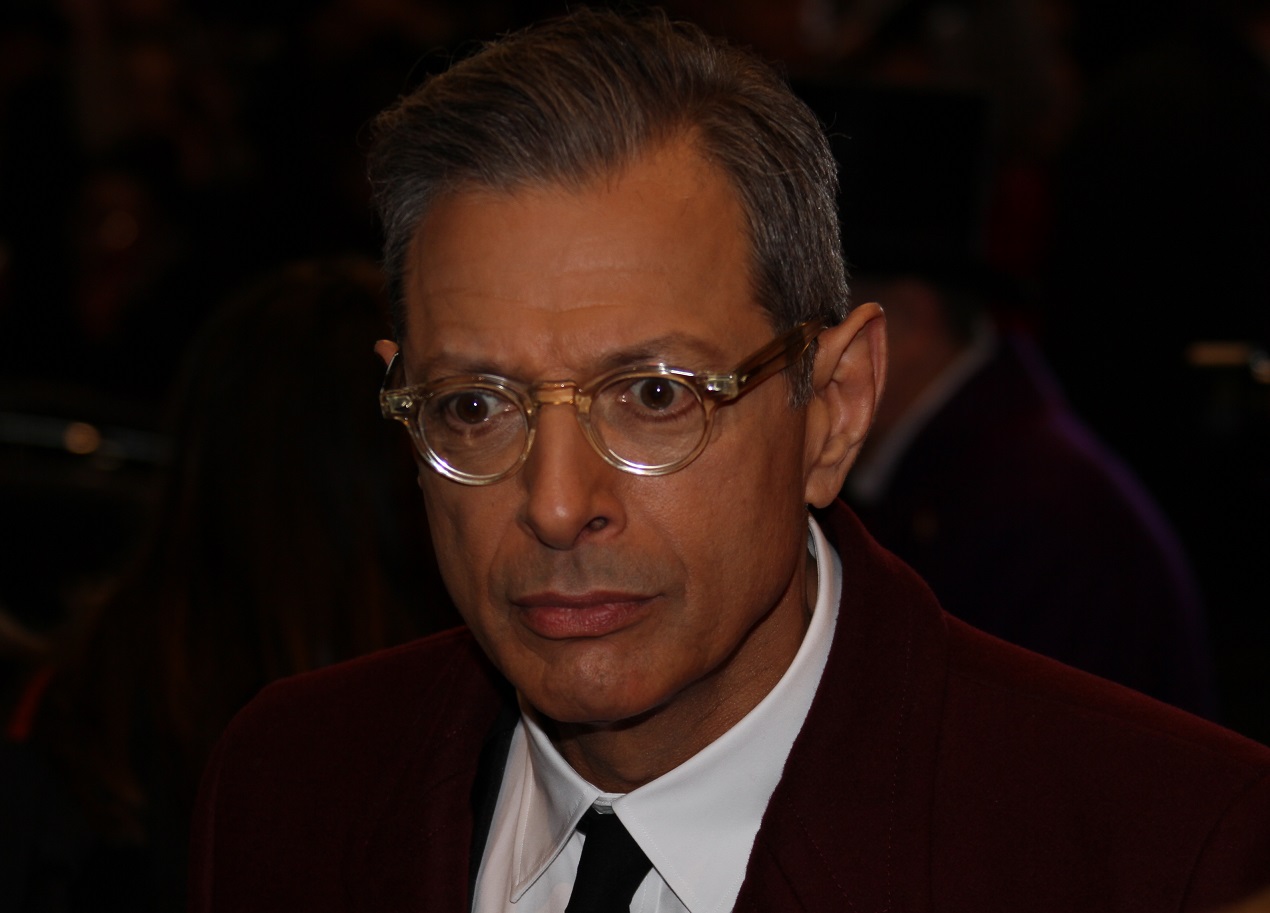 Jeff Goldblum wearing white shirt and red jacket is looking at side- 2014