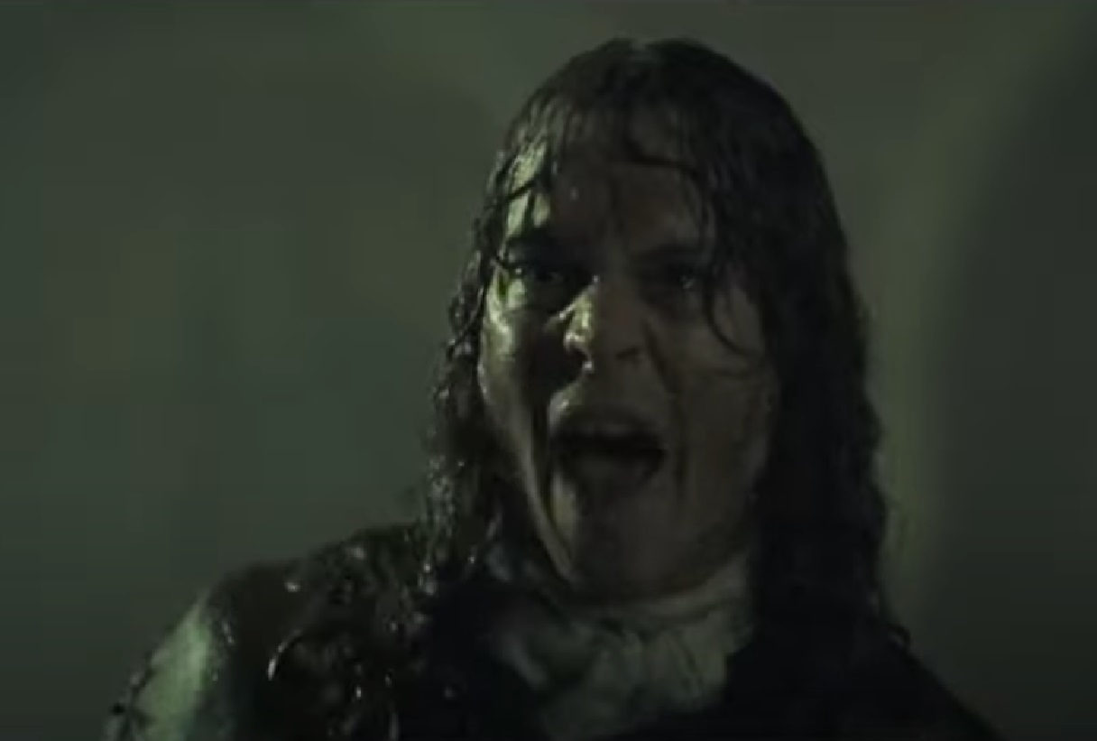 Screenshot: Johnny Deep with long hair is standing in the rain outside - from The Libertine (2004)