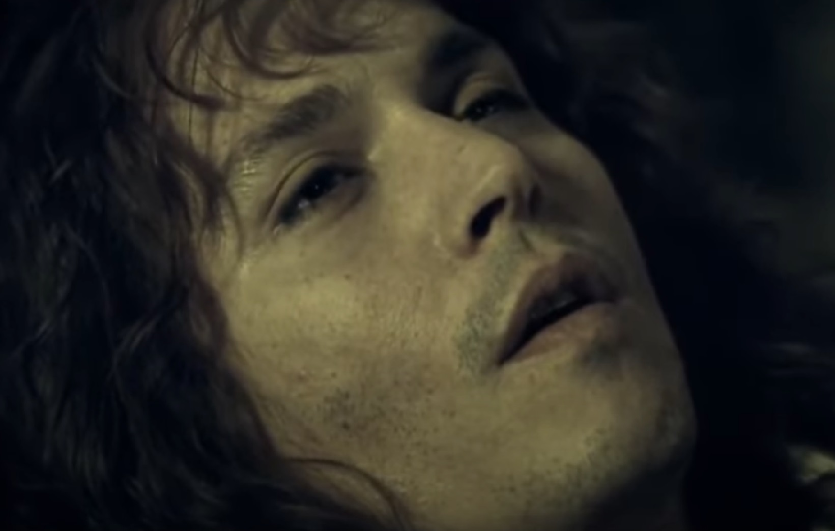 Screenshot: Johnny Deep with long hair is laying on the bed - from The Libertine (2004)