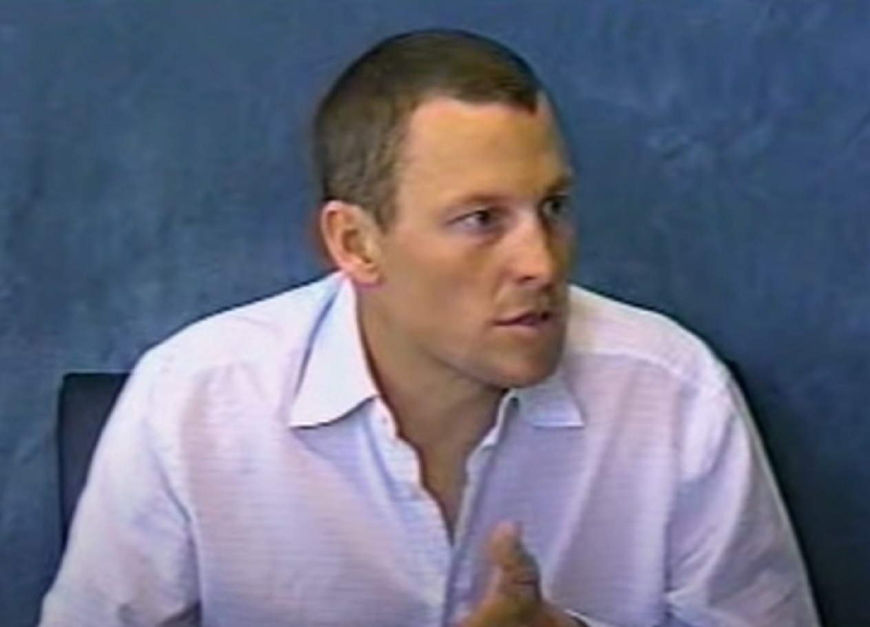 Screenshot: Lance Armstrong wearing white shirt is talking and looking at side - from  The Armstrong Lie (2013)