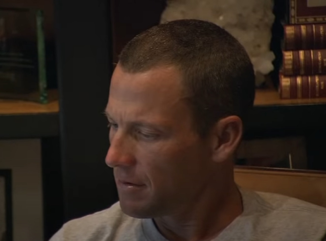 Screenshot: Lance Armstrong wearing grey shirt is looking at side - from The Armstrong Lie (2013)