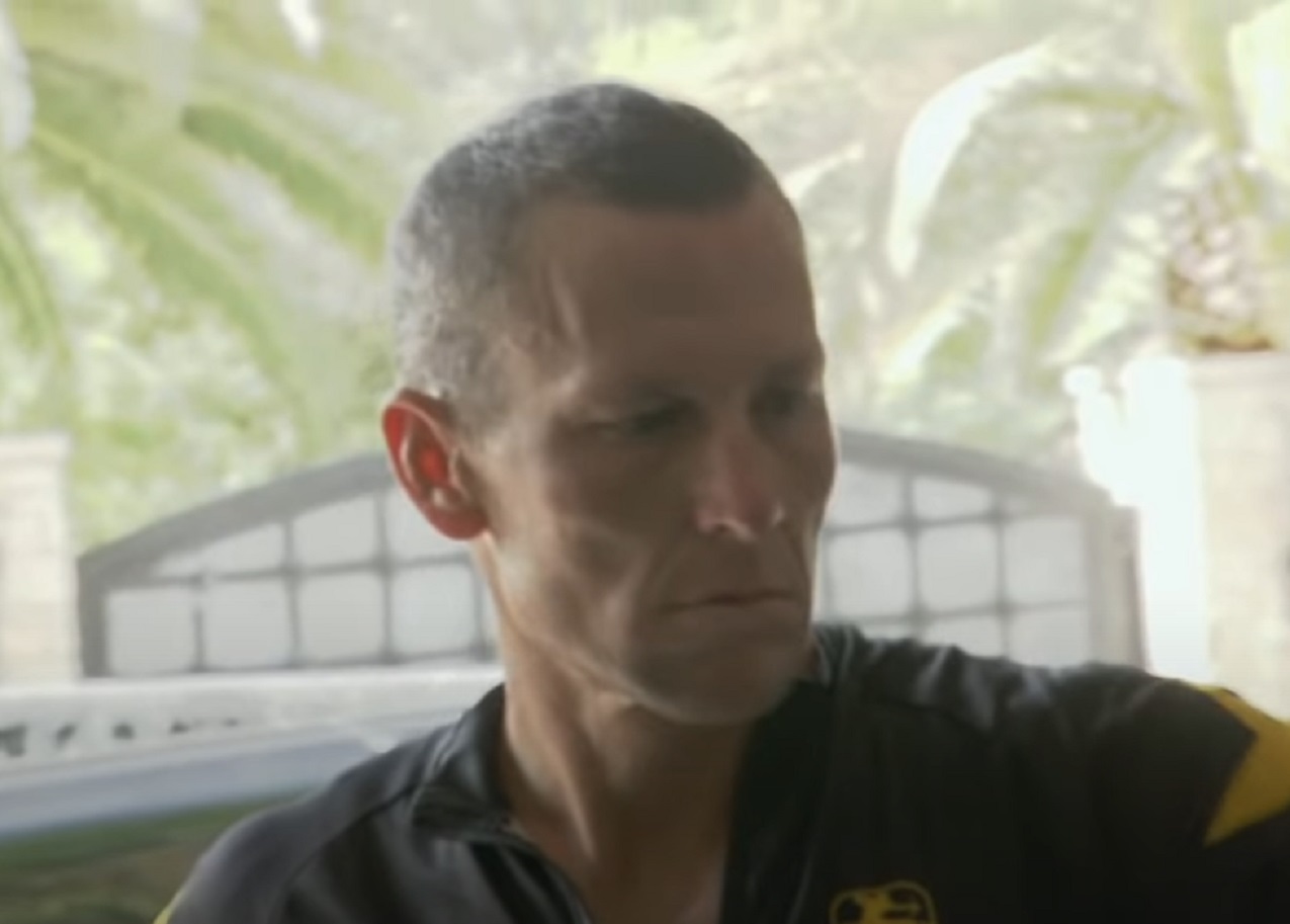 Screenshot: Lance Armstrong wearing black shirt is looking at side - from The Armstrong Lie (2013)