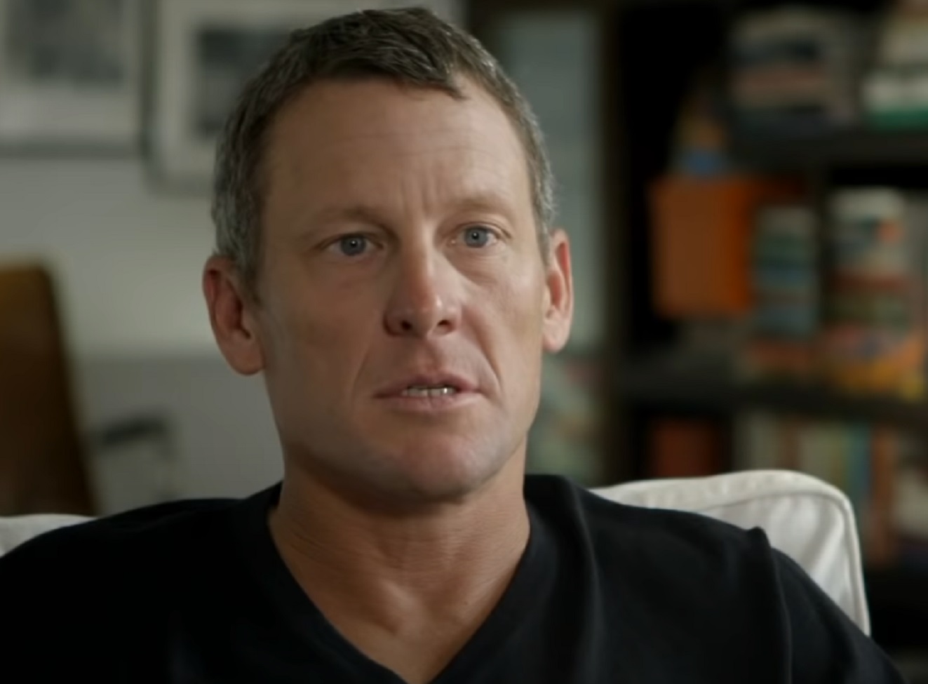 Screenshot: Lance Armstrong wearing black shirt is looking at side - from The Armstrong Lie (2013)