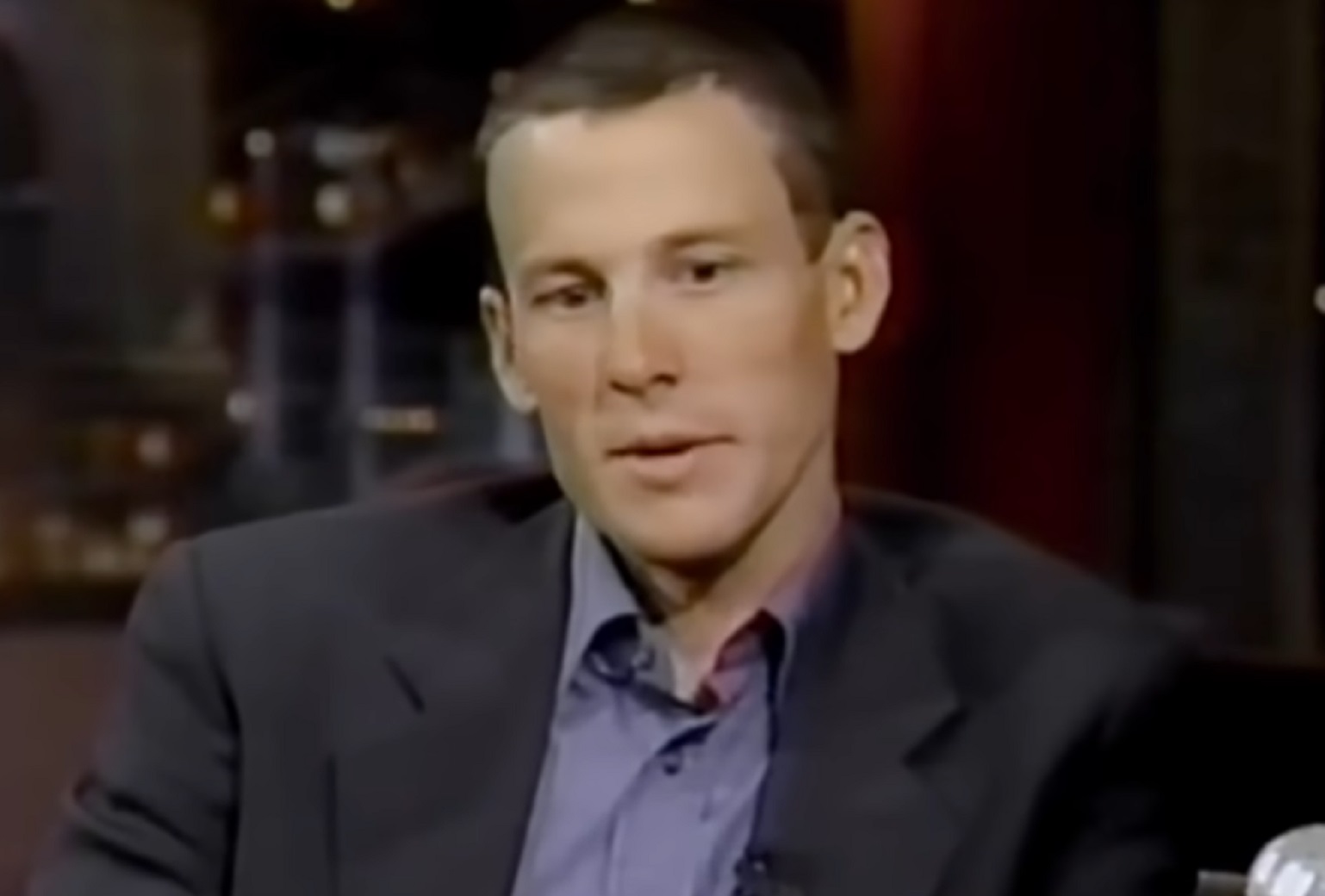 Screenshot: Lance Armstrong wearing suit is looking down with sad face - from Stop At Nothing- The Lance Armstrong Story (2014)