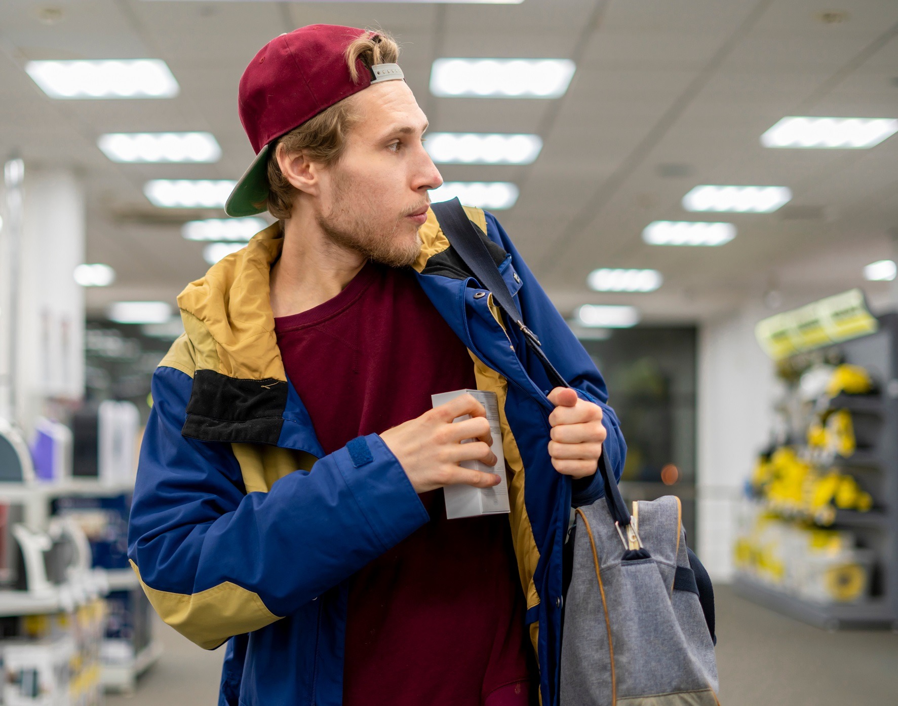 Shoplifter in the supermarket is stealing new product.