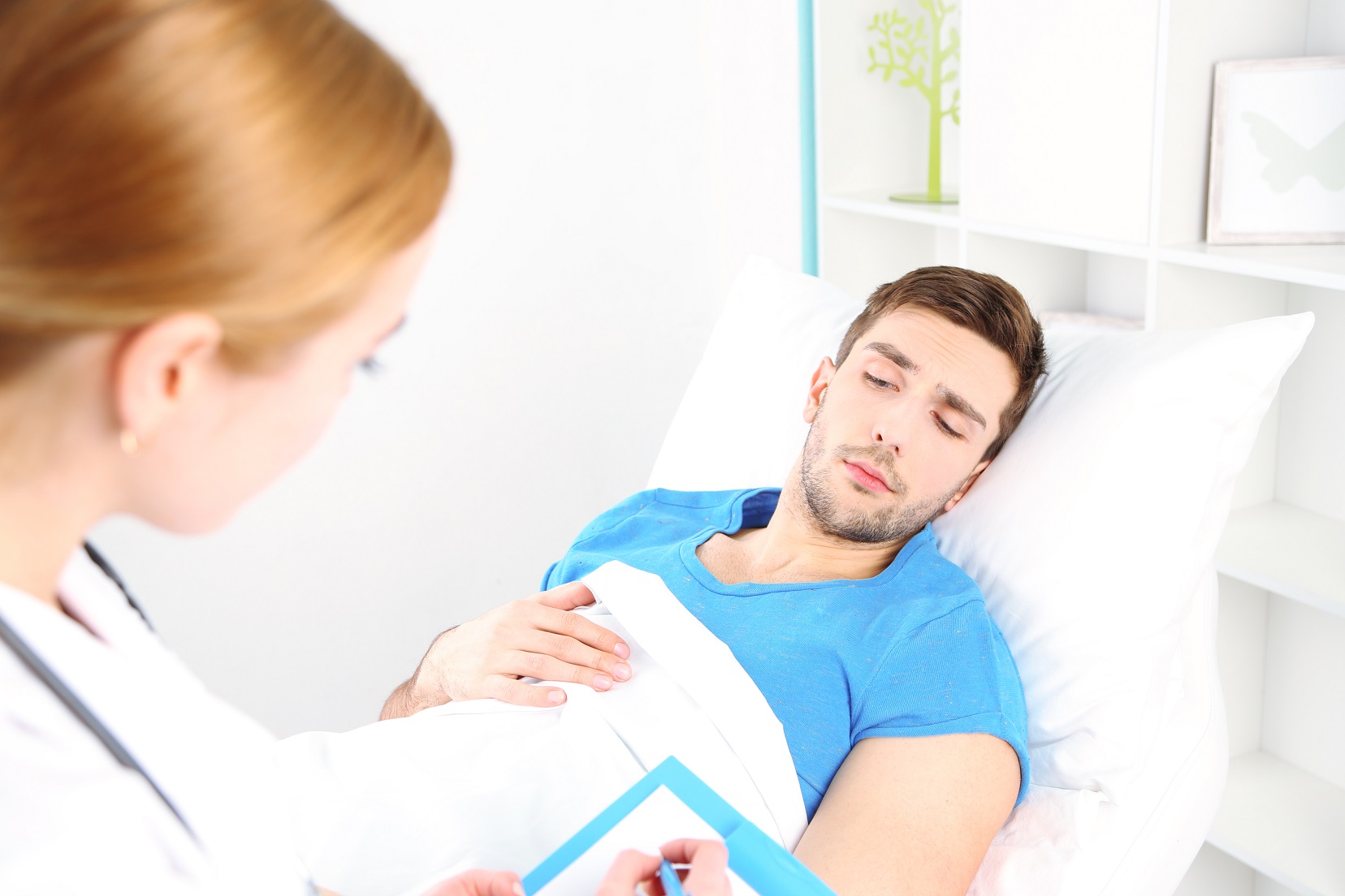 Doctor filling medical report for patient.