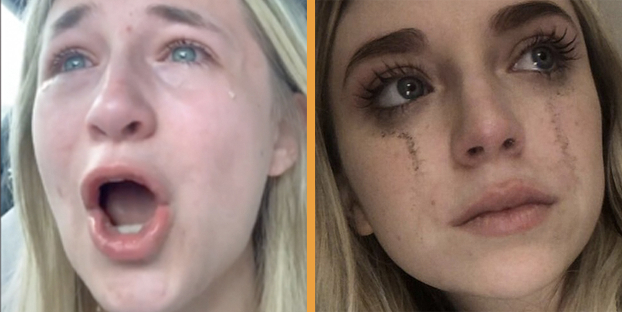 Man in black sweater is seating on the bed near woman in black sweater holding a phone.