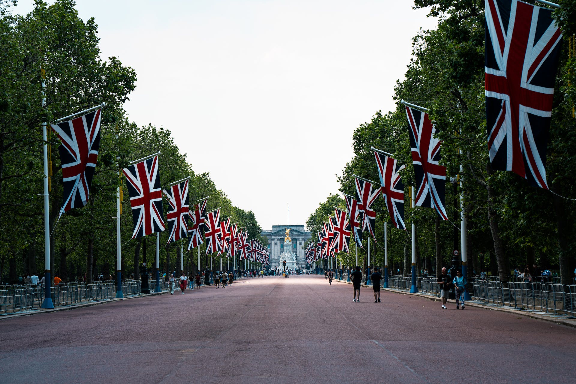 people walking along the mall in london with british flags over