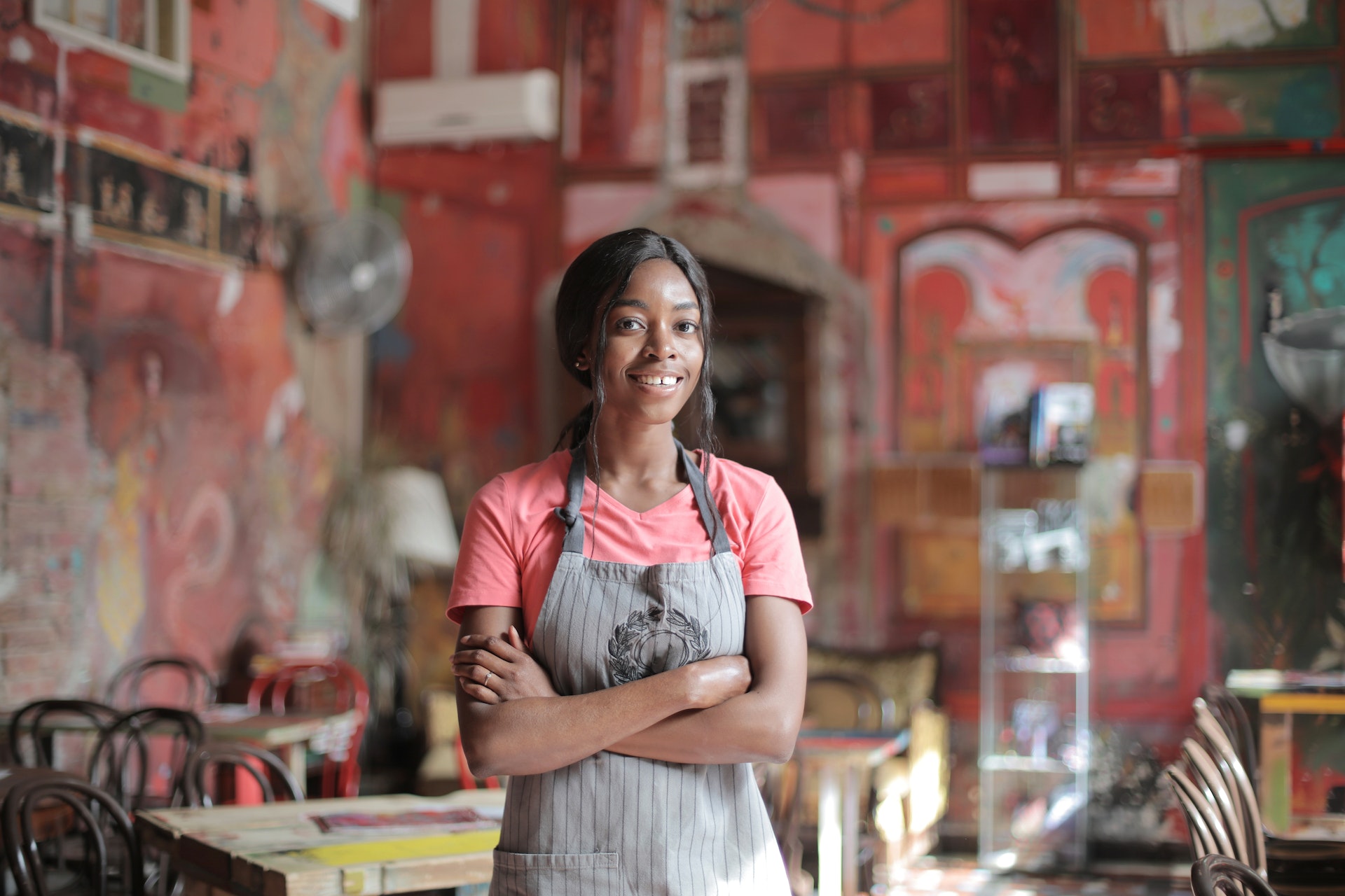 Waitress in pink t-shirt and apron looking at the camera