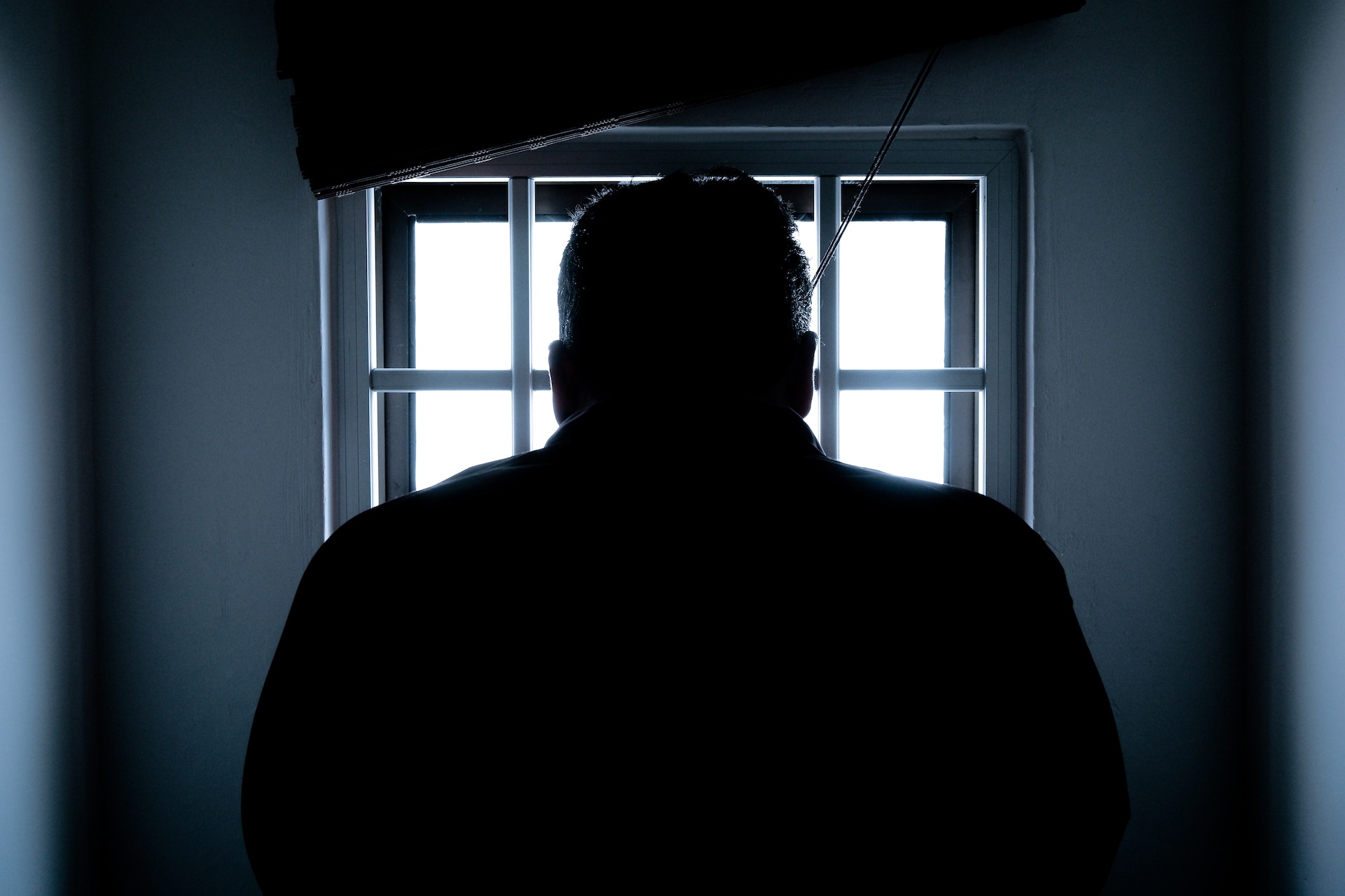 rear view of a silhouette man in prison cell