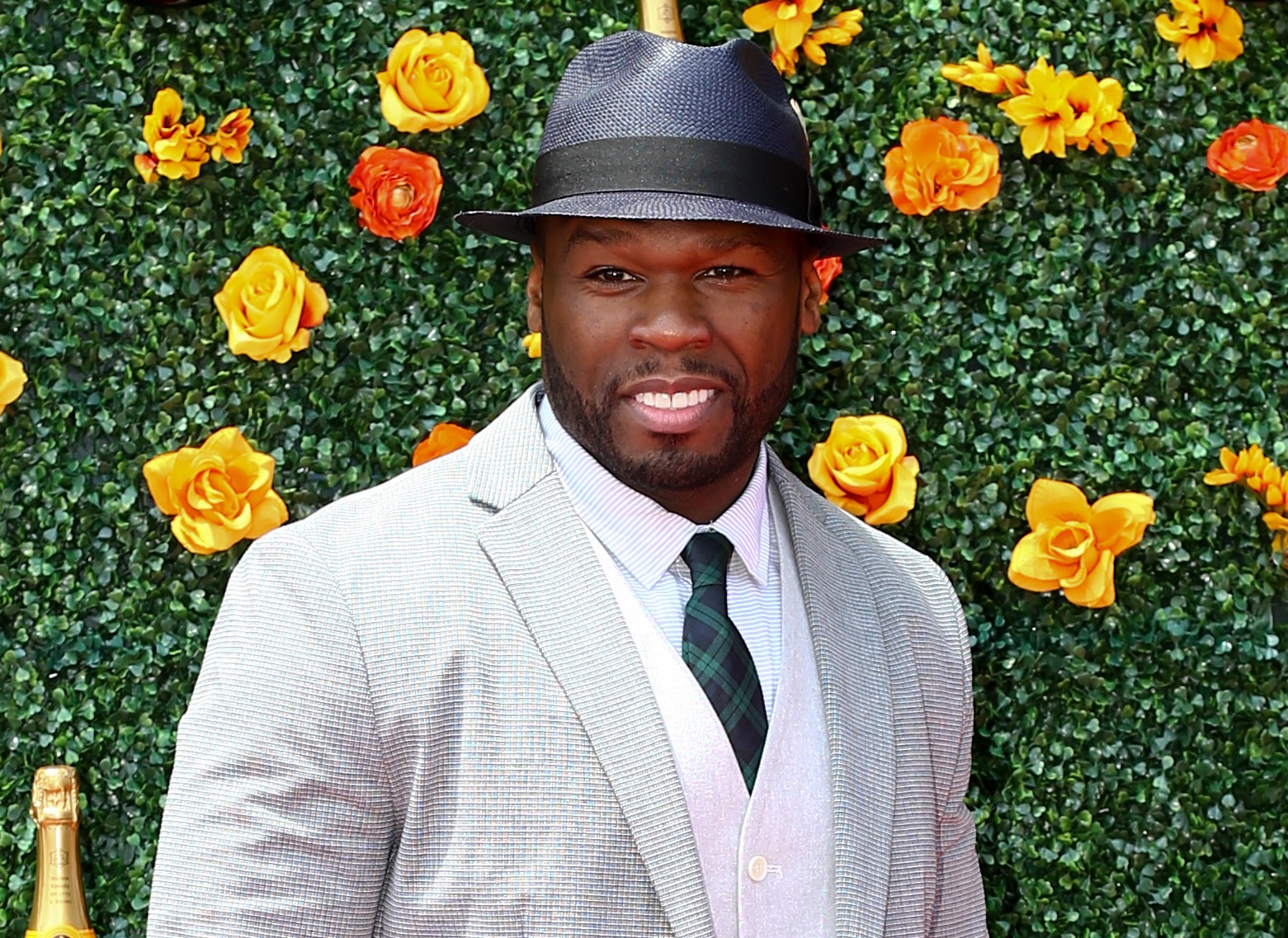 Rapper/actor Curtis Jackson, aka 50 Cent wearing grey suit and hat is smiling at camera - 2015