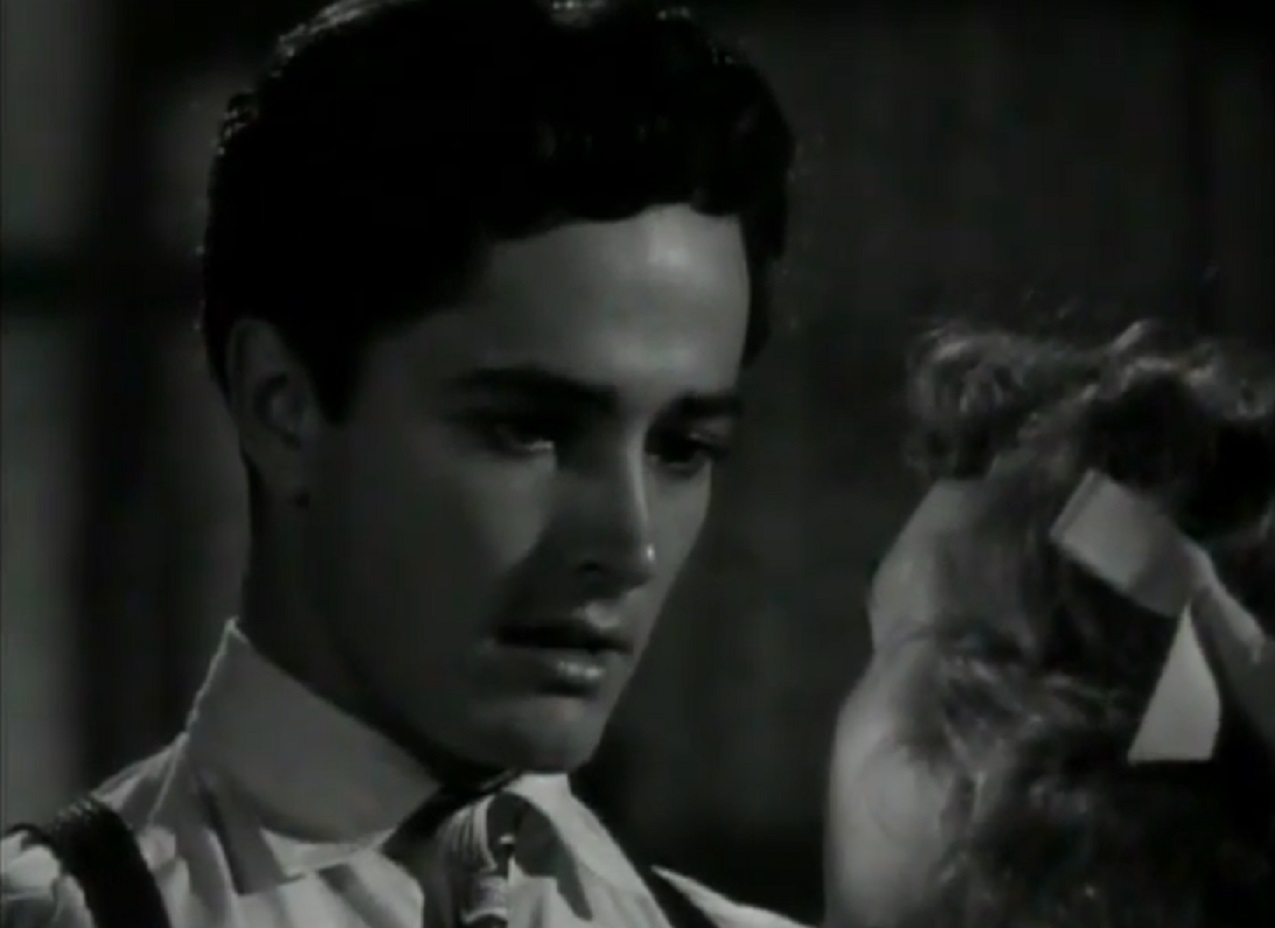Screenshot of John Derek wearing shirt and tie and taking with woman - from Knock On Any Door (1949)