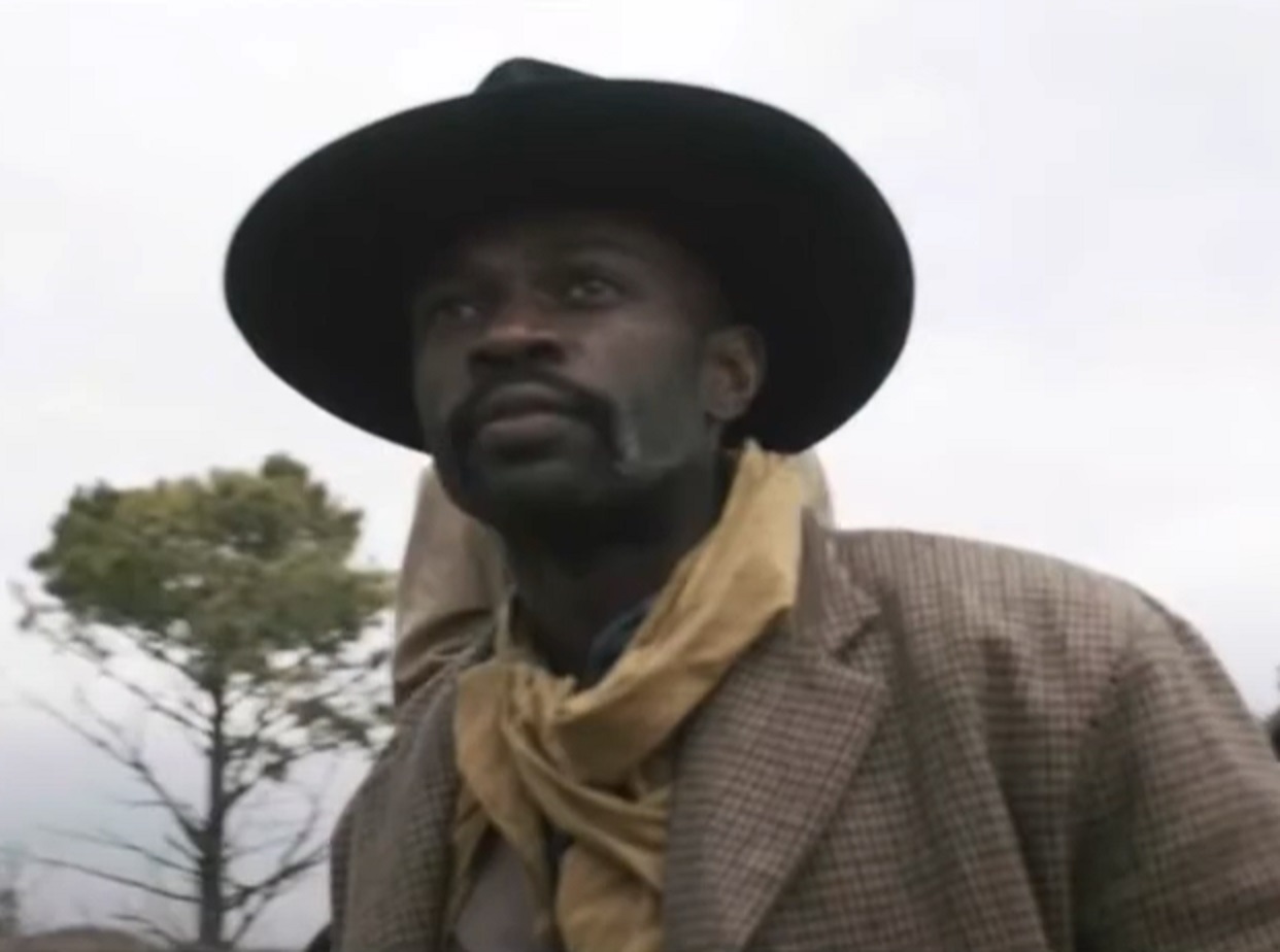Screenshot: Bass Reeves wearing brown jacket and hat standing outside - from H.e.l.l on the Border (2019)