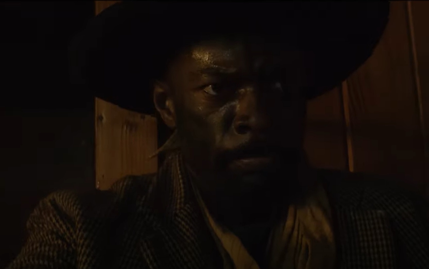 Screenshot:Bass Reeves wearing brown jacket and hat standing outside - from H.e.l.l on the Border (2019)
