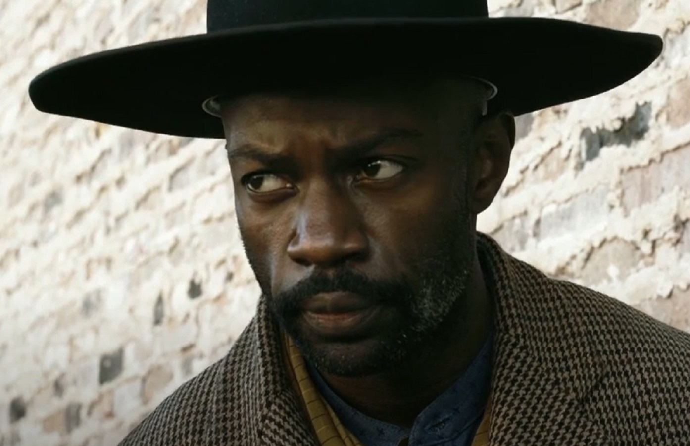 Screenshot: Bass Reeves wearing brown jacket and hat standing outside - from H.e.l.l on the Border (2019)