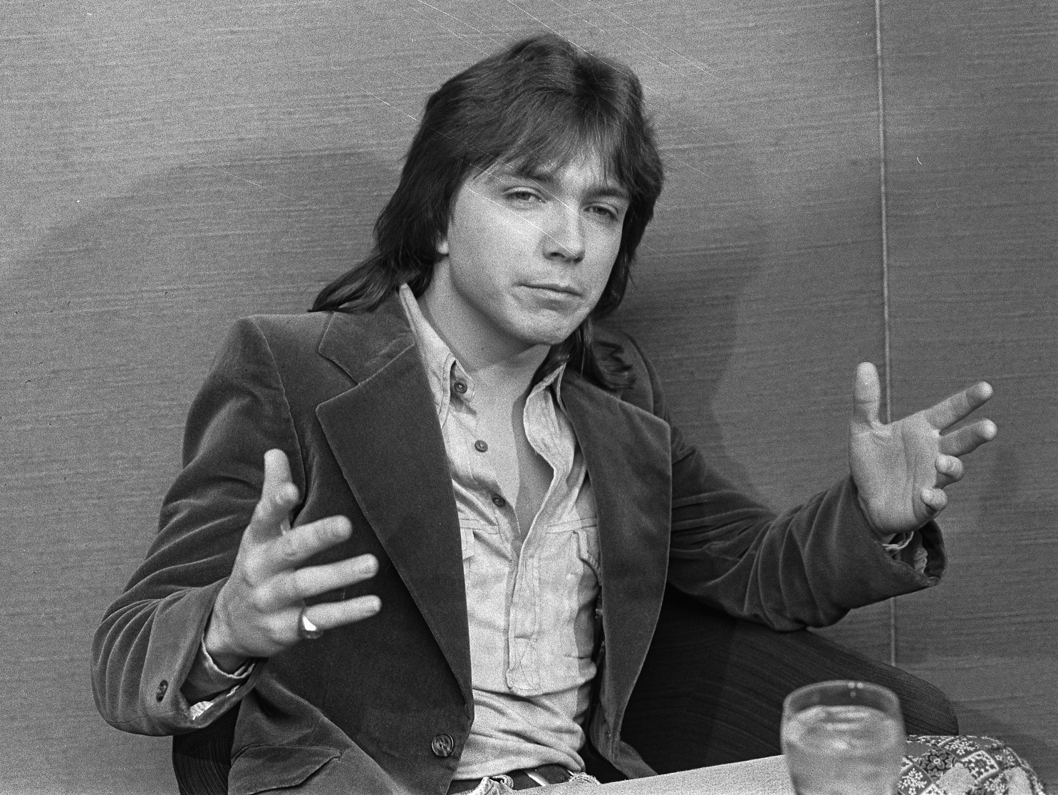 David Cassidy wearing grey shirt and jacket is seating with open arms - 1973