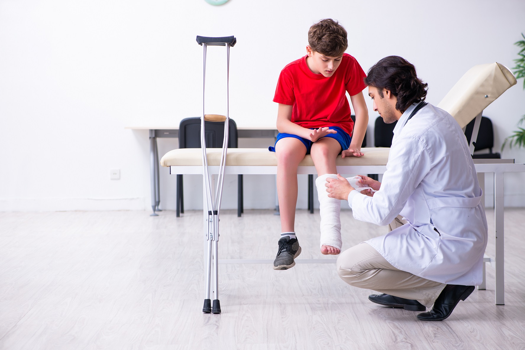 Leg injured boy visiting young doctor.