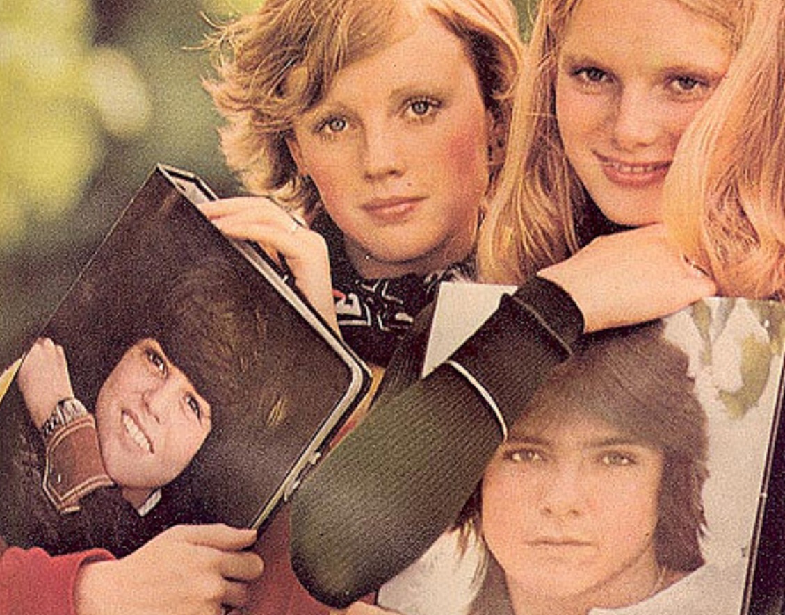 Fans holding a notebooks in hands with David Cassidy portrait on it.