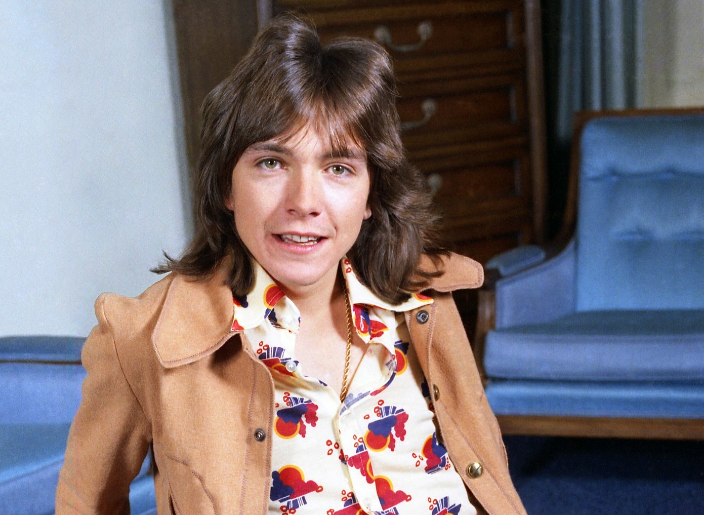 David Cassidy wearing flower shirt and brown  jacket is looking at camera and smiling - 1972