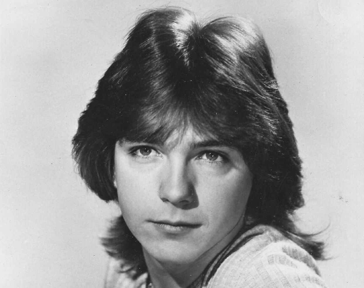 David Cassidy wearing white sweater is looking at side - 1972