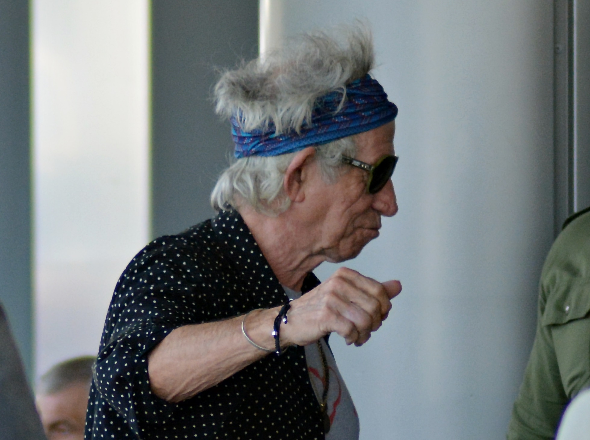 Keith Richards wearing black shirt and blue bandana is walking outside - 2018