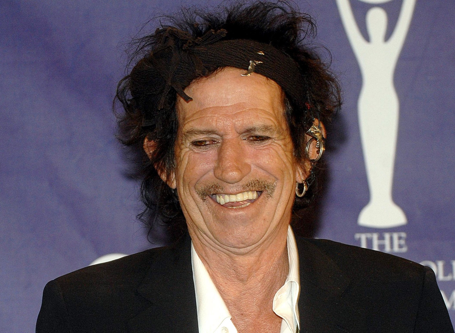 Keith Richards wearing black suit is smiling - 2007
