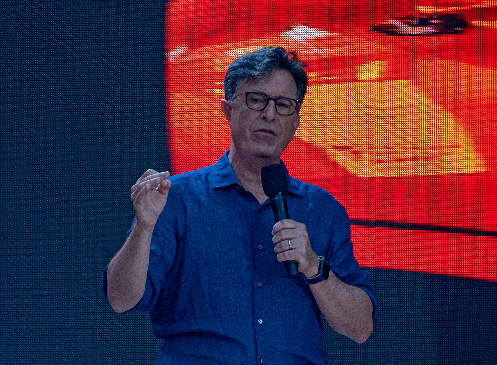 Stephen Colbert wearing blue shirt is talking on the stage - 2021