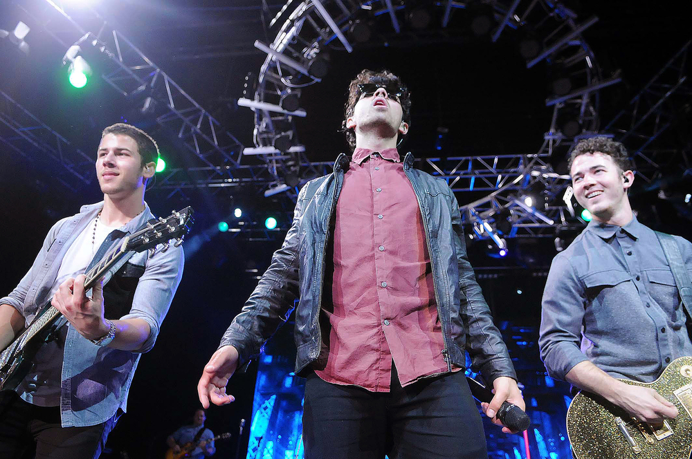 Jonas Brothers with musicians on stage