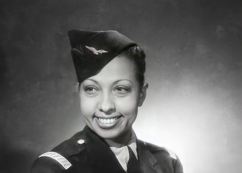 Grayscale portrait photo of Josephine Baker in army uniform smiling