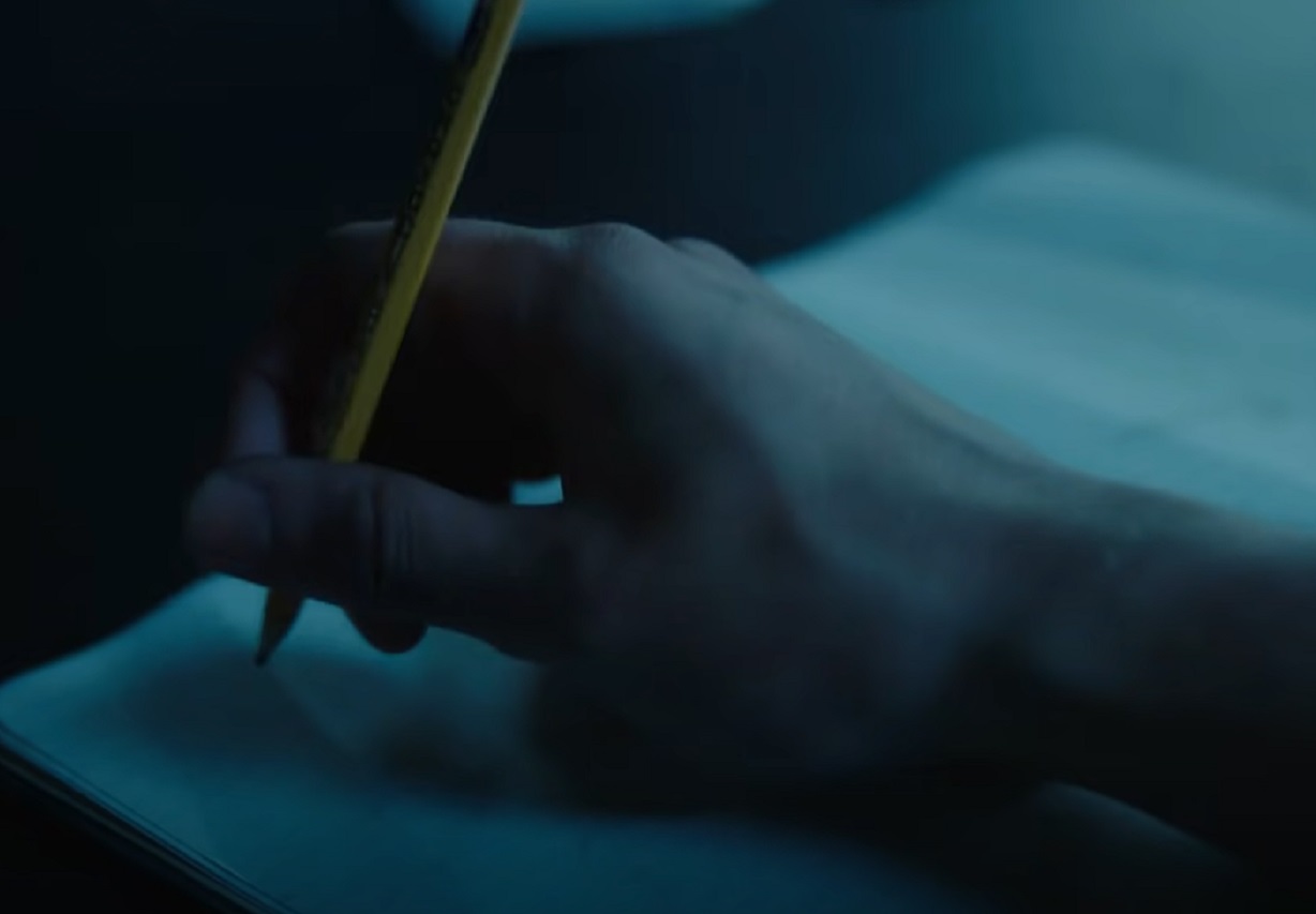 Screenshot: J.D. Salinger wearing dark suit is writing - from Rebel in the Rye (2017)
