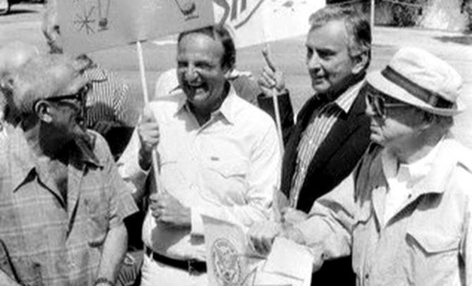 Gore Vidal, Richard Brooks, Bo Goldman, and Billy Wilder on The Screen Writers Guild strike holding banners looking at each other