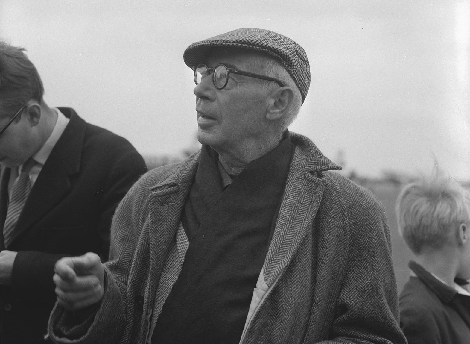 Grayscale Portrait Photo Of Henry F. Miller wearing a gray coat hat glasses looking sideways