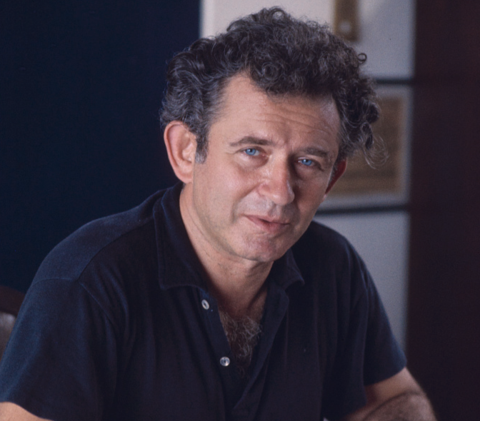 Portrait Photo Of Norman Mailer wearing a dark blue polo t-shirt facing the camera