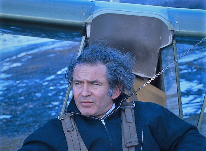 Photo Of American novelist Norman Mailer sitting in a glider wearing a blue outfit