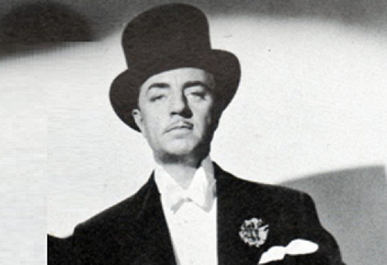 William Powell wearing black suit and hat in movie The Thin Man.
