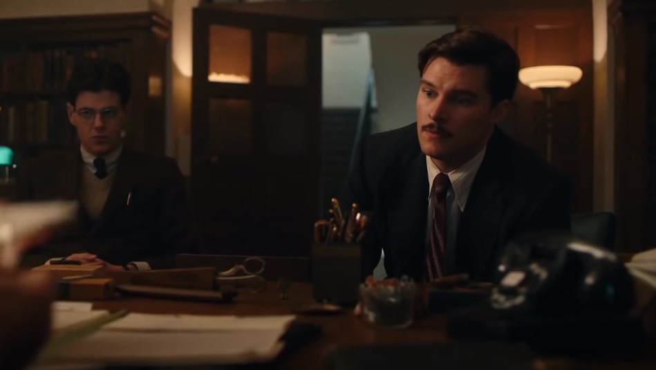 Jack Reynor as Jack Parsons in  Strange Angel and  Richard Onsted sitting in office in suits