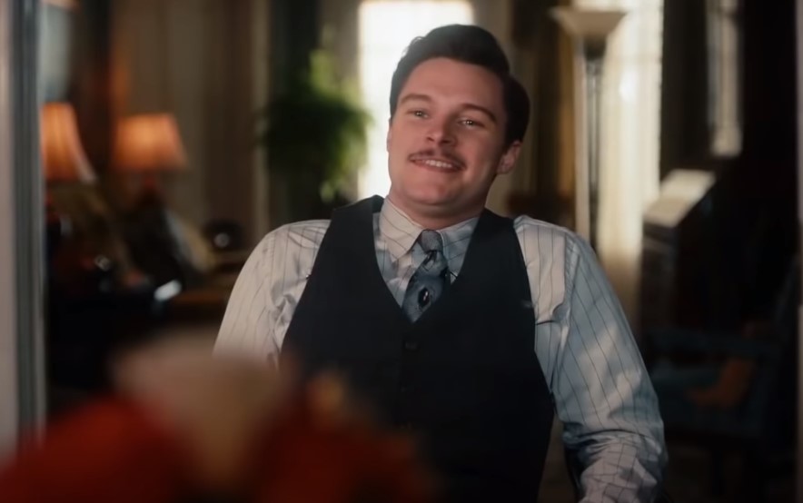 Jack Reynor as Jack Parsons in  Strange Angel sitting on a chair