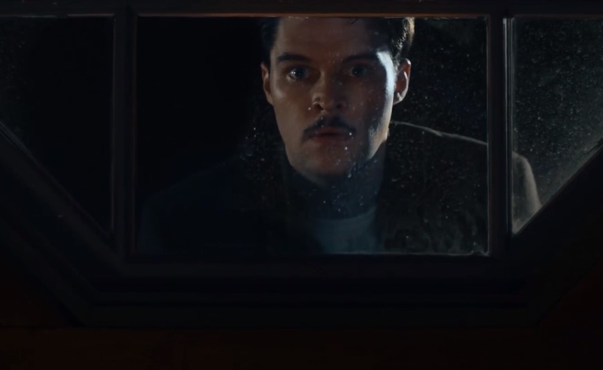 Jack Reynor as Jack Parsons in  Strange Angel looking trough a widow