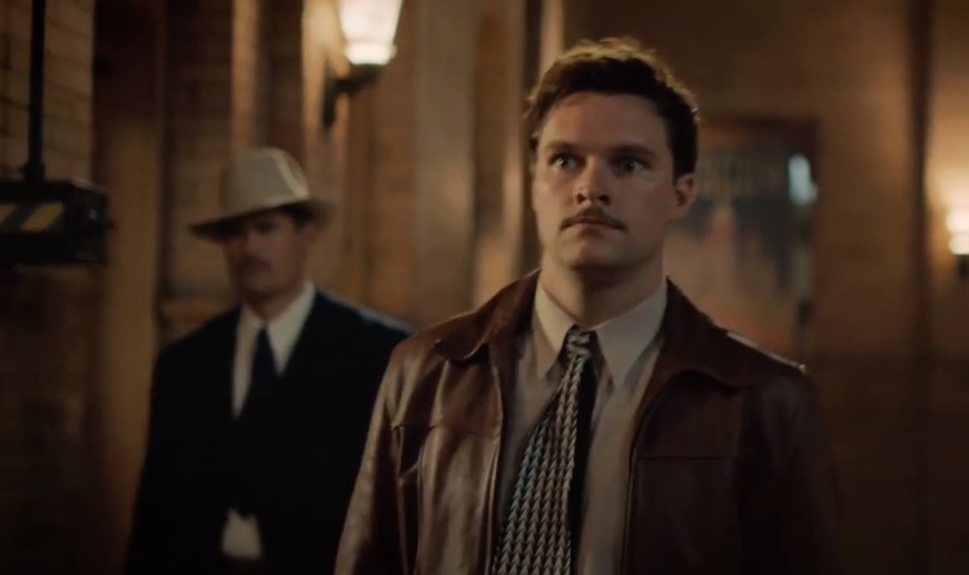 Jack Reynor as Jack Parsons in leather jacket looking at left