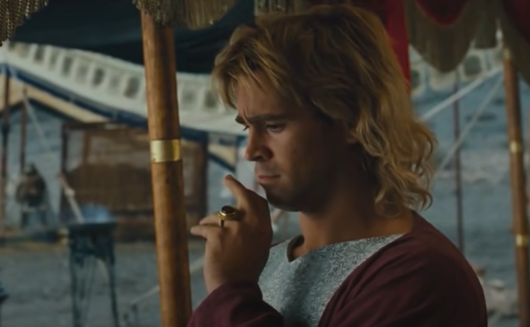 Screenshot from the Movie Alexander (2004), depicting alexander the Great wearing a red gown with his arm raised