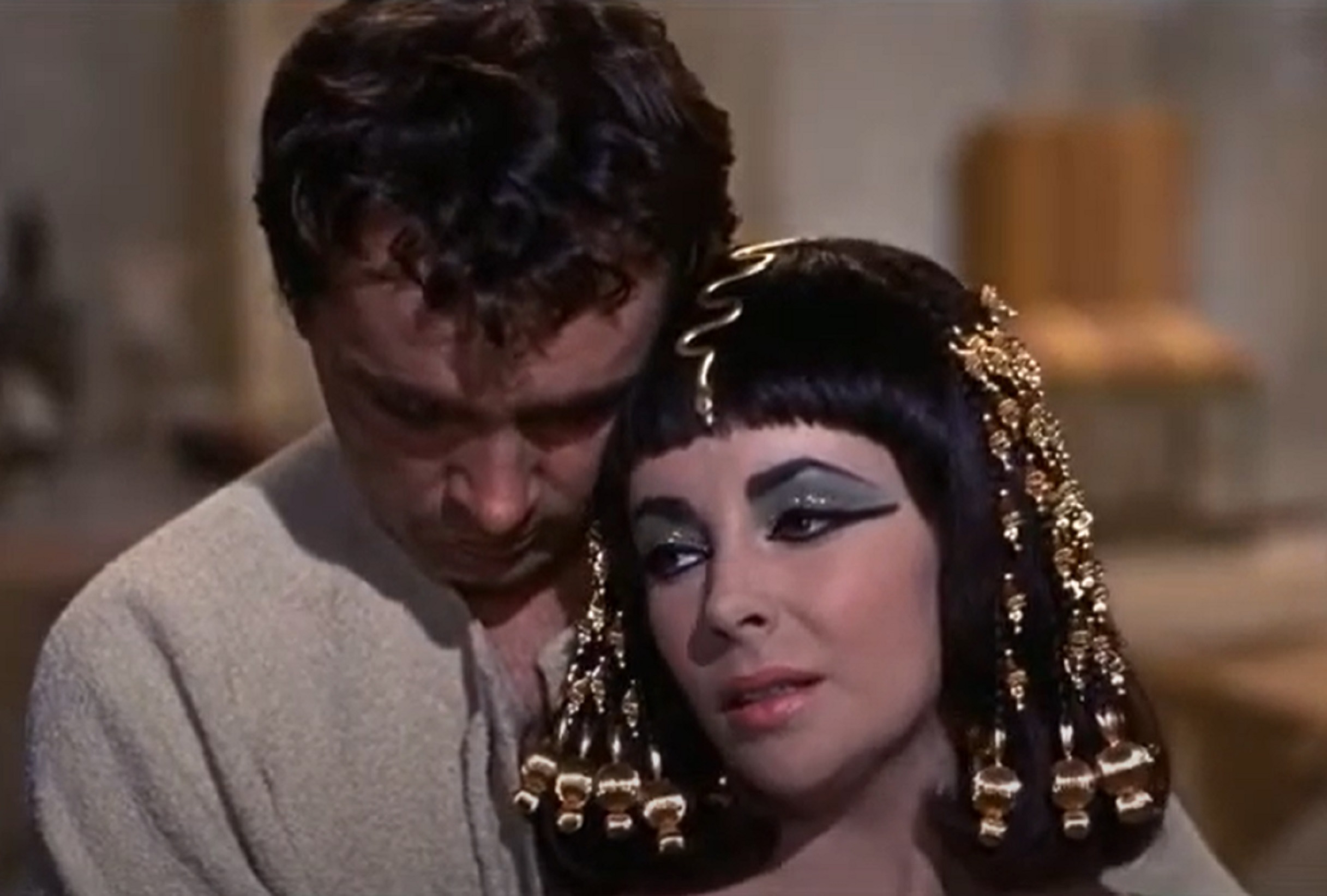 Screenshot: (Elizabeth Taylor) Cleopatra with long hair is standing next to a male person - from Cleopatra (1963)