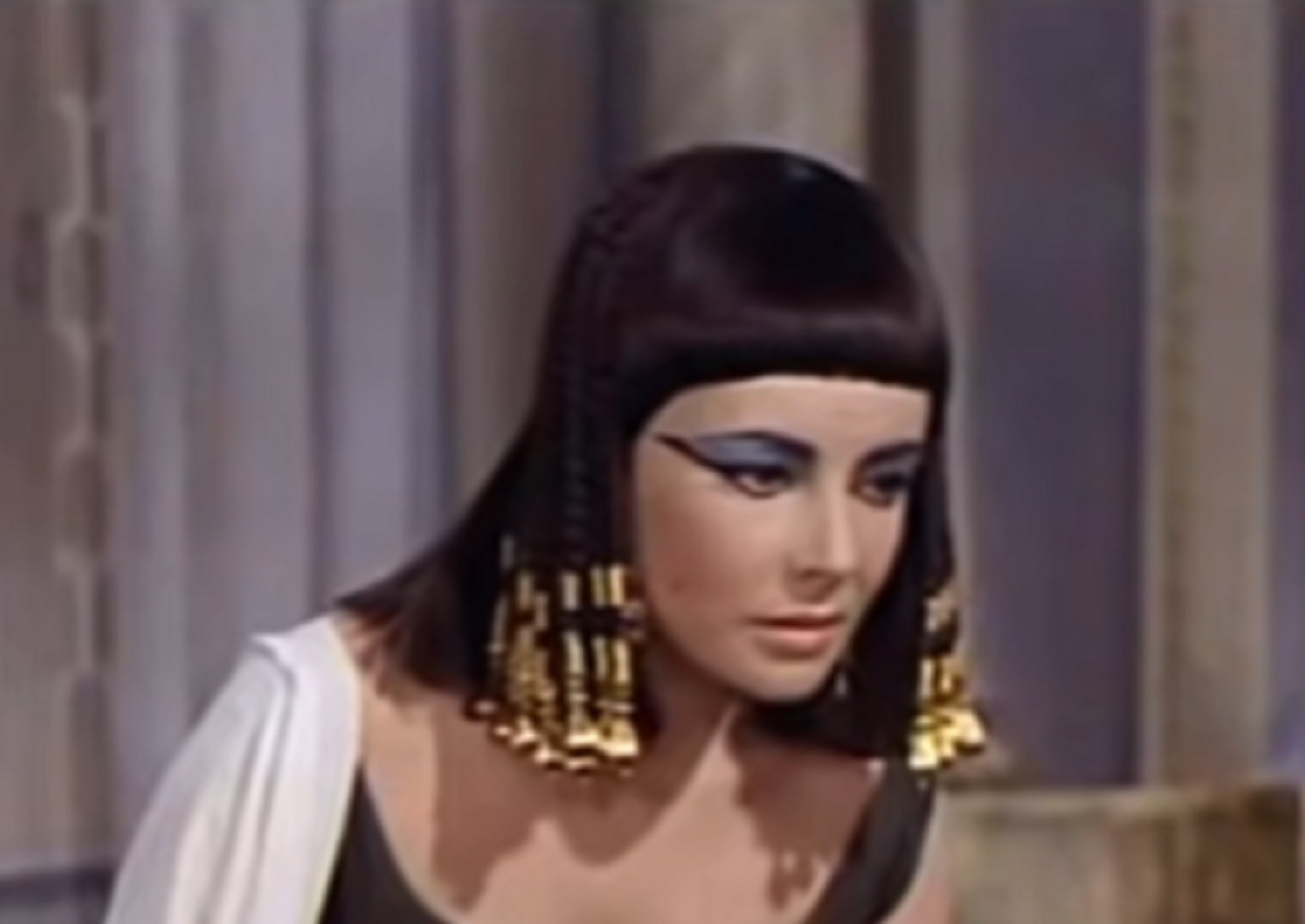 Screenshot: (Elizabeth Taylor) Cleopatra wearing B&W dress is looking at side - from Cleopatra (1963)