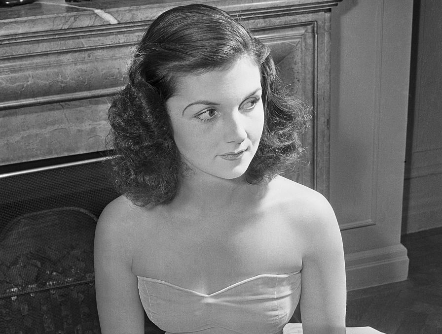 Grayscale Photo of Miss Brenda Frazier wearing a dusty pink velvet hoopskirt gown