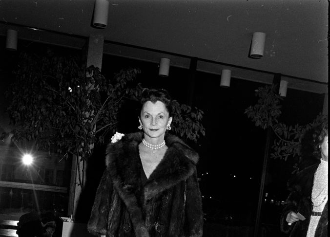 Grayscale Photo of Brenda Frazier wearing a black coat black hat and pearl necklace