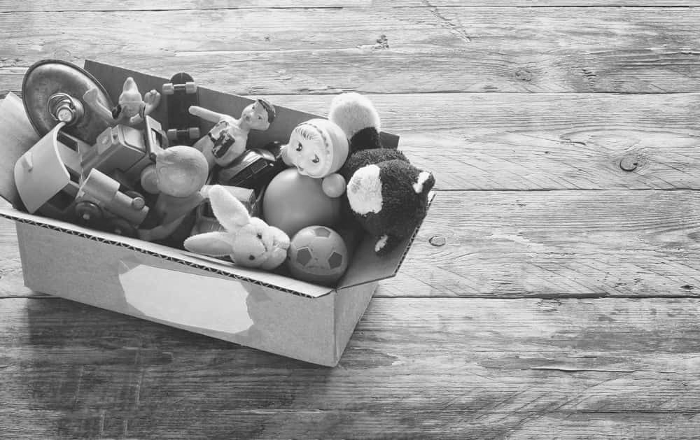 cardboard box with old dusty toys, glued note with the word