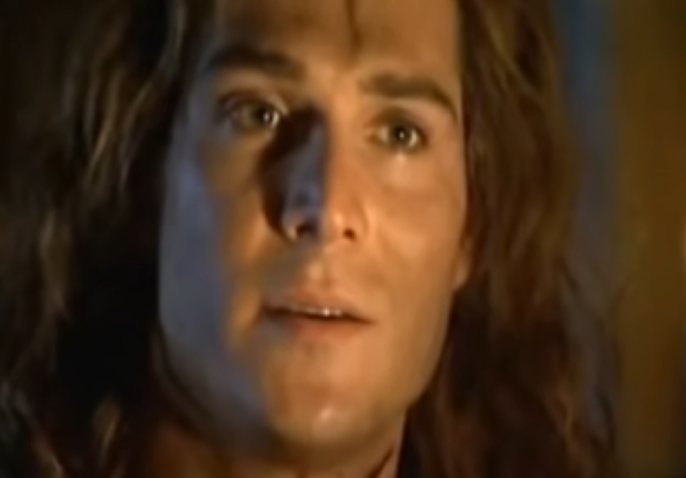 Screenshot: (Mark Umbers) Perkin Warbeck with long hair is looking at camera - from Princes in the Tower (2005).