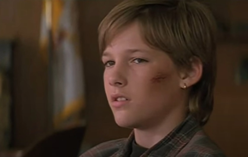 Screenshot of the actor Brad Renfro from the Movie The Client (1994) depicting a boy with a bruised face wearing a earring
