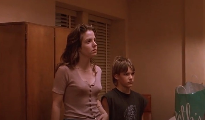 Screenshot of the actor Brad Renfro and the actress Mary-Louise Parker from the Movie The Client (1994) depicting a brother and sister standing next to each other