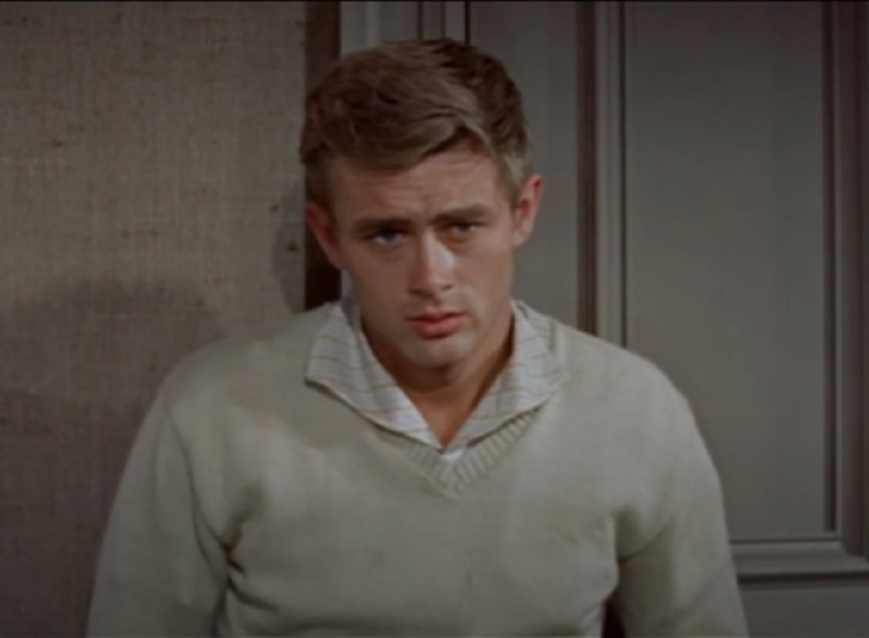 Screenshot: photo of James Dean wearing white shirt and sweater is looking with sad face - from the East Of Eden (1955).