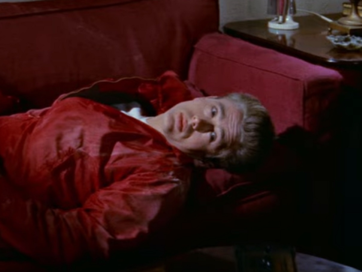 Screenshot: photo of James Dean wearing red jacket is laying on the bed - from Rebel Without A Cause (1955).